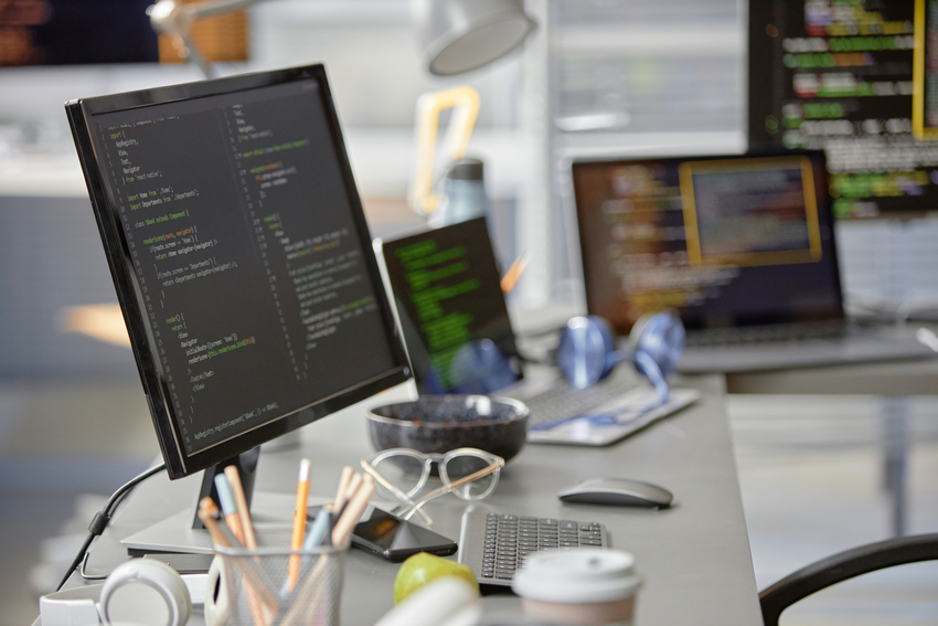 Computer Monitor with Code Lines in Office Setup Background shot of software engineer working desk with multiple computer screens displaying programming code in IT office, copy space